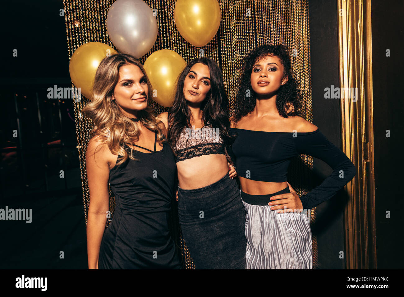 Portrait de trois jeunes filles élégantes à la discothèque. Groupe de femmes friends Standing together in party au pub. Banque D'Images