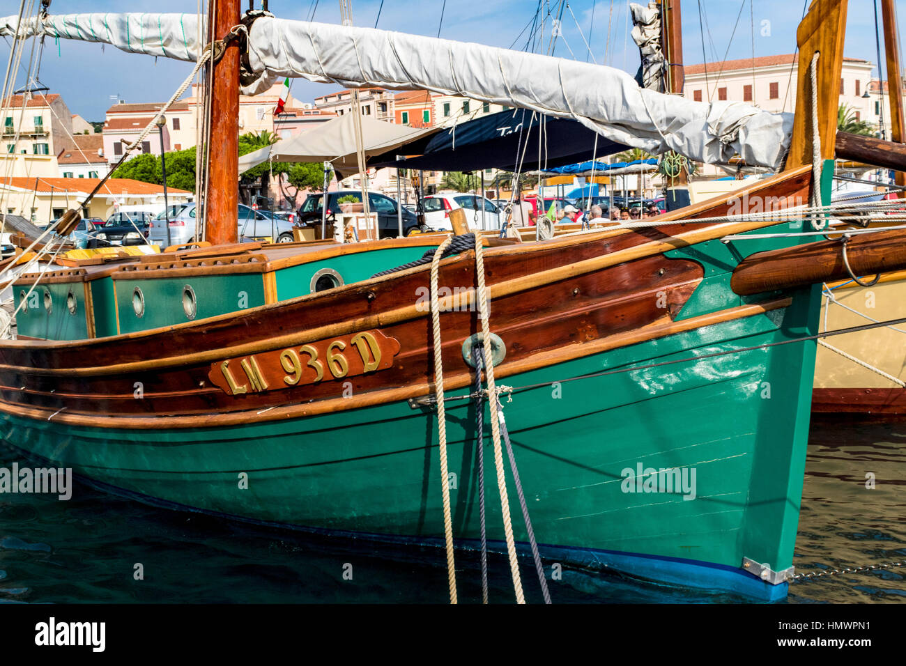 Proue coloré Détail d'un schooner Antique amarrés dans le Port de La Maddalena avec le quai et bâtiments de mer, Sardaigne, Italie Banque D'Images