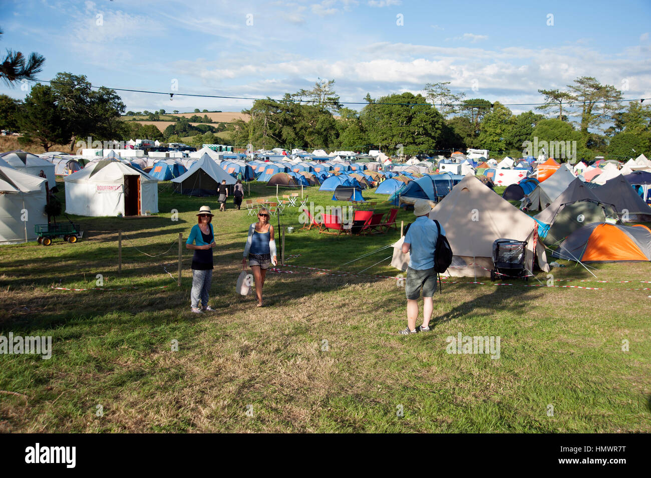 Les gens marcher dans la tente de camping au Festival Port Eliot Cornwall Banque D'Images