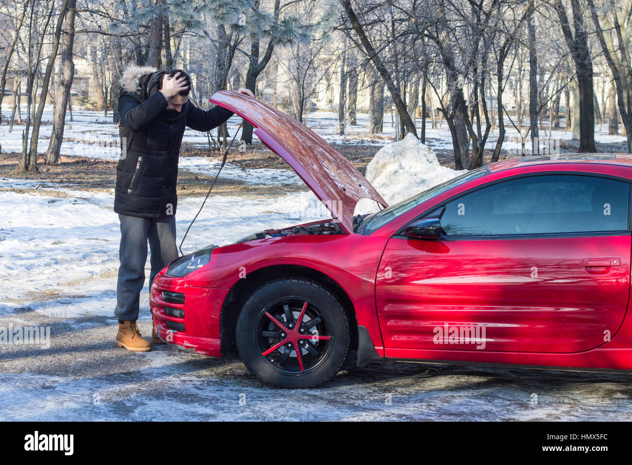 L'homme en difficulté avec sa voiture sport .Il est inquiet, il a les mains sur sa tête. Geste émotif Banque D'Images