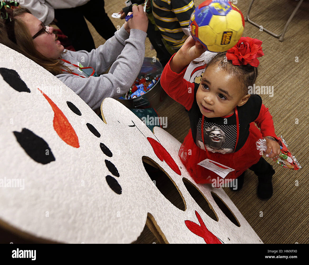 Rock Island, Iowa, États-Unis. 11Th Feb 2016. Amarionna Douglas, 2, lance une balle à un bonhomme de gagner un prix au cours de l'Illinois et l'Iowa Centre for Independent Living Maison de carnaval à Rock Island, Illinois Samedi 10 Décembre, 2016. Tyson Fresh Foods et Miss Penny's Day Care a aidé l'hôte de l'événement. Crédit : Jeff Cook/Quad-City Times/ZUMA/Alamy Fil Live News Banque D'Images