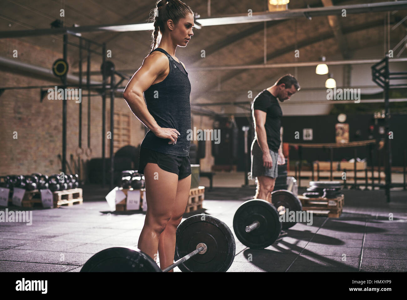 Les gens qui se trouvent en musculaire sportive barbells en salle de sport. L'intérieur horizontal tourné Banque D'Images