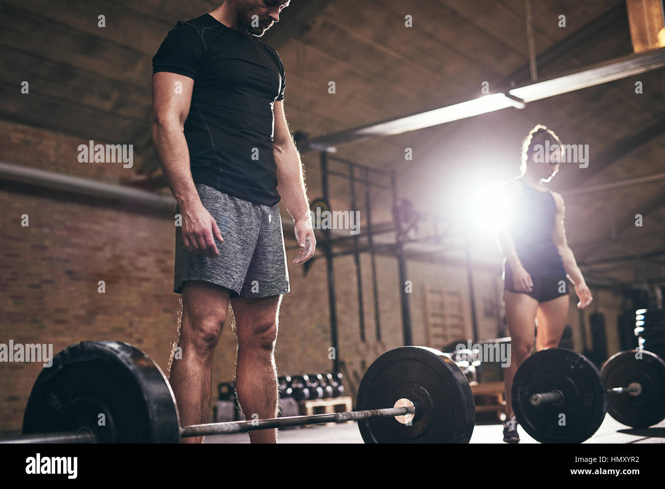 L'homme et de la femme sportive prépare à faire l'exercice avec des barres. L'intérieur horizontal tourné Banque D'Images