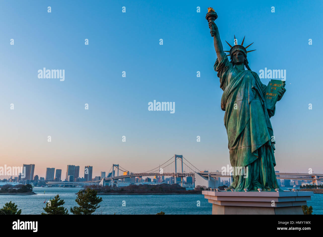 Lady Liberty juxtaposés se tiennent près de pont en arc-en-ciel à Odaiba Banque D'Images