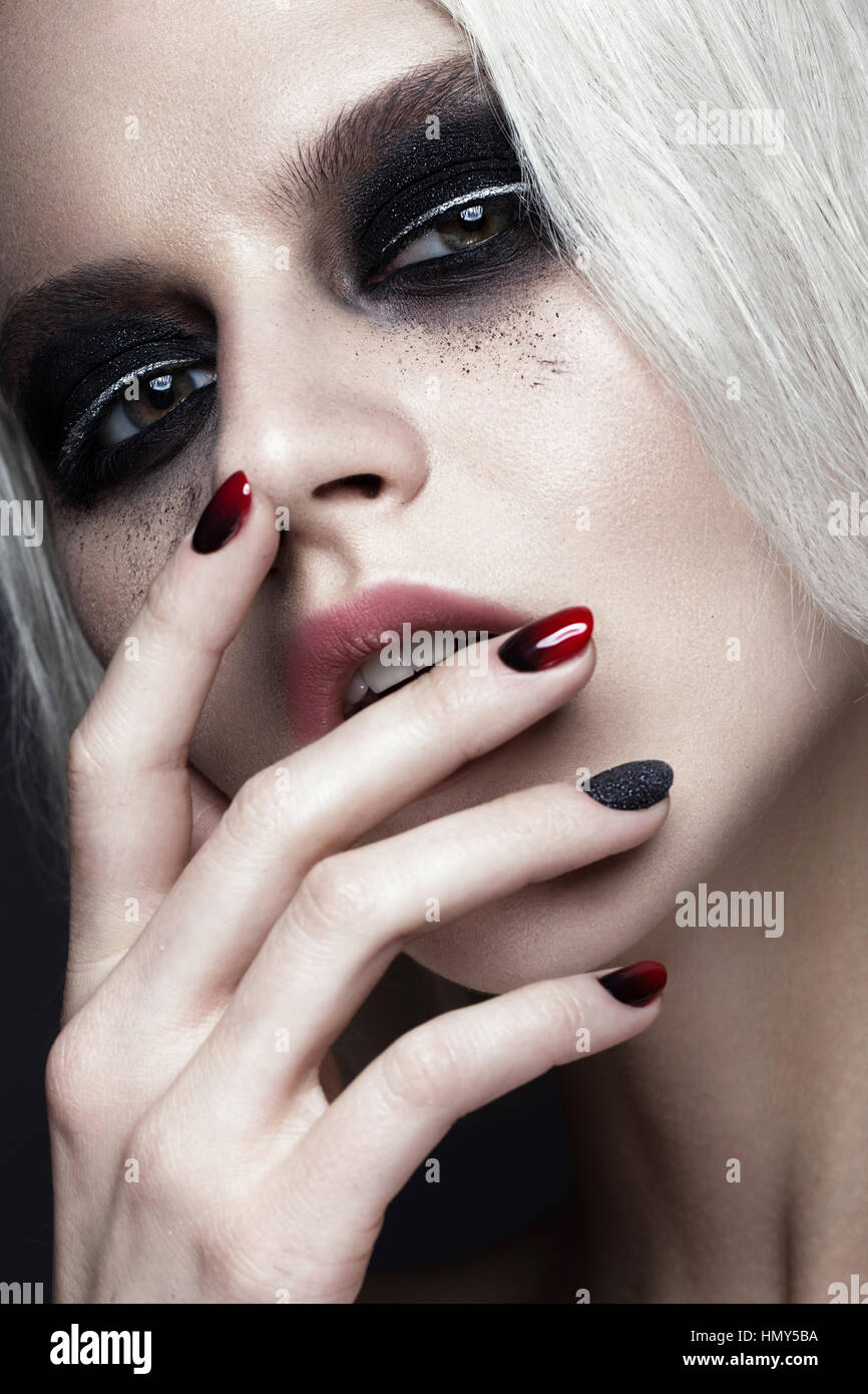 Belle fille blonde avec smokey foncé et maquillage manucure ongles art design. beauté visage. Banque D'Images