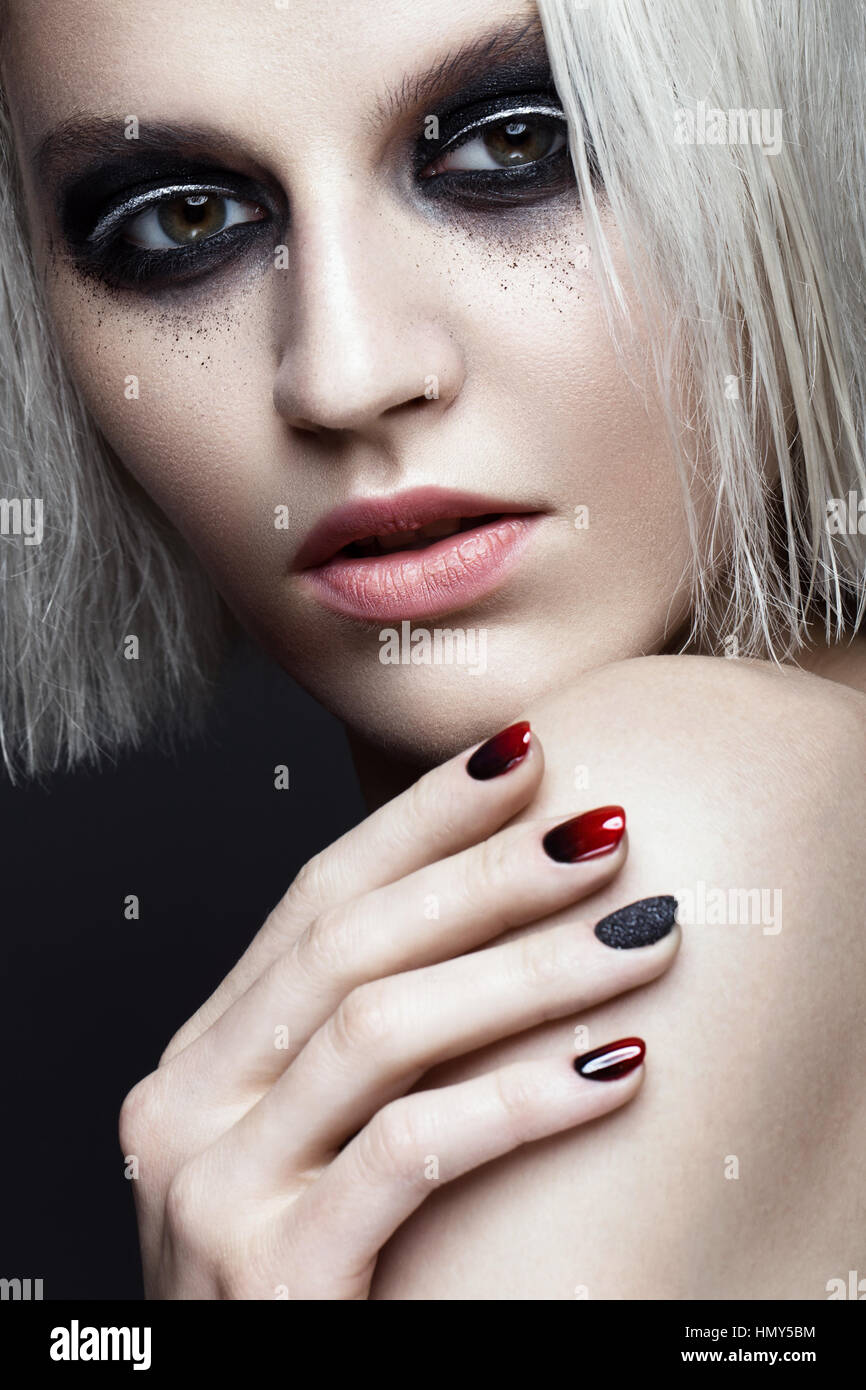 Belle fille blonde avec smokey foncé et maquillage manucure ongles art design. beauté visage. Banque D'Images