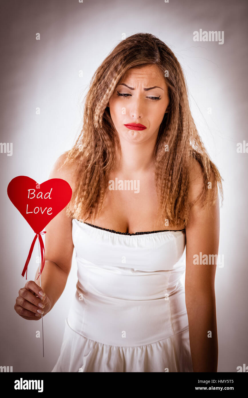 Belle fille malheureuse pleurer et holding broken cœur rouge. Concept de la Saint-Valentin. Banque D'Images