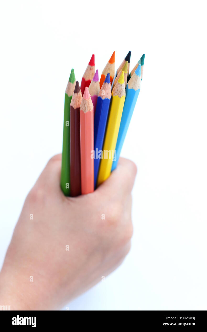 Close up of main droite agrippant color pencils isolated against white background Banque D'Images Close up of main droite agrippant color pencils isolated against white background Banque D'Images