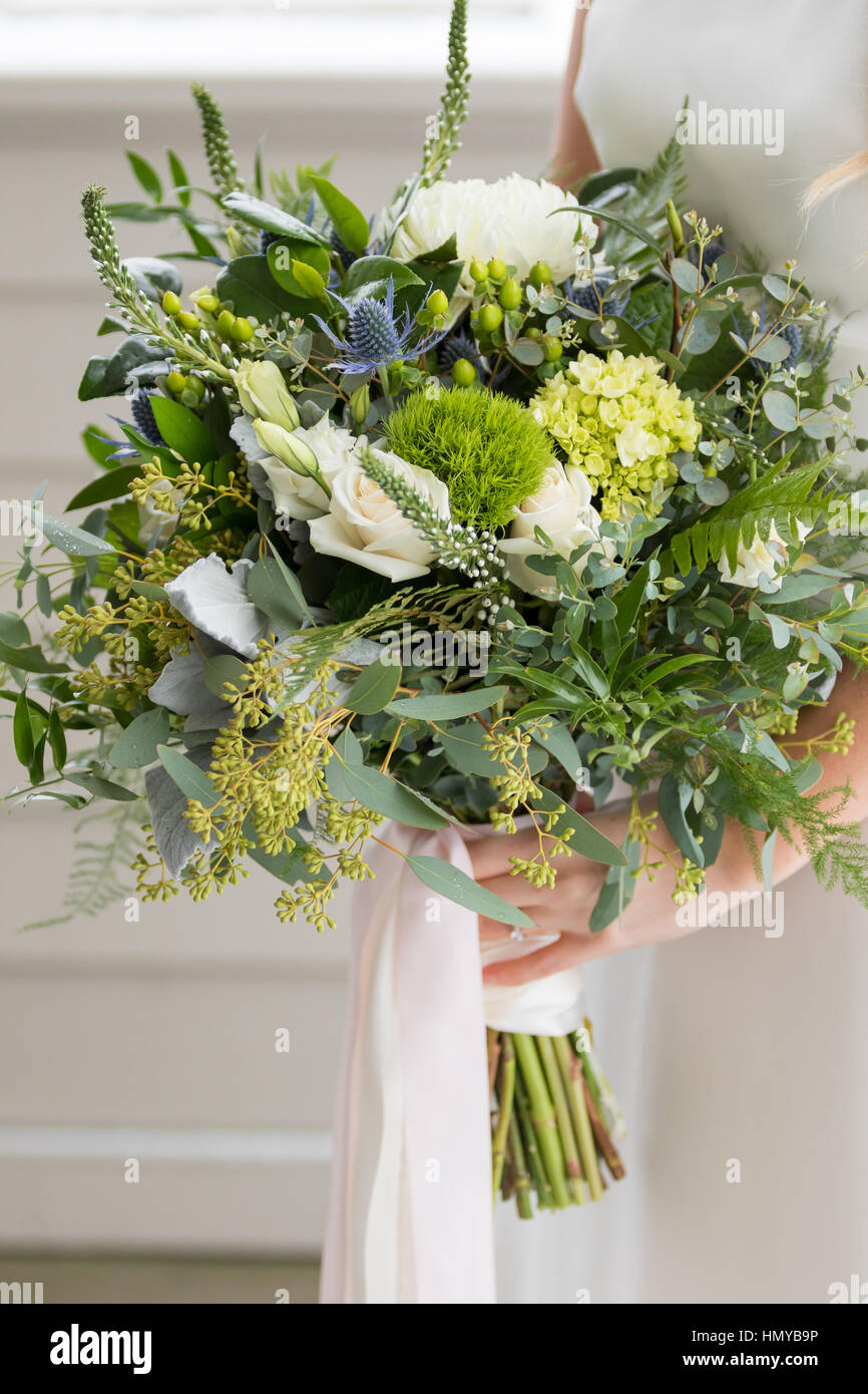 Bouquet de mariée à la main d'une jeune mariée le jour de son mariage. Banque D'Images