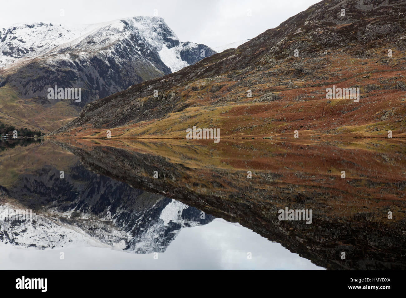 Vue vers l'ouest le long de Llyn Ogwen dans le parc national de Snowdonia dans le Nord du Pays de Galles. Les pics couverts de neige de Snowdonia en arrière-plan. Banque D'Images