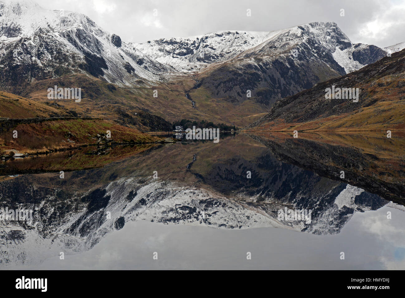 Vue vers l'ouest le long de Llyn Ogwen dans le parc national de Snowdonia dans le Nord du Pays de Galles. Les pics couverts de neige de Snowdonia en arrière-plan. Banque D'Images