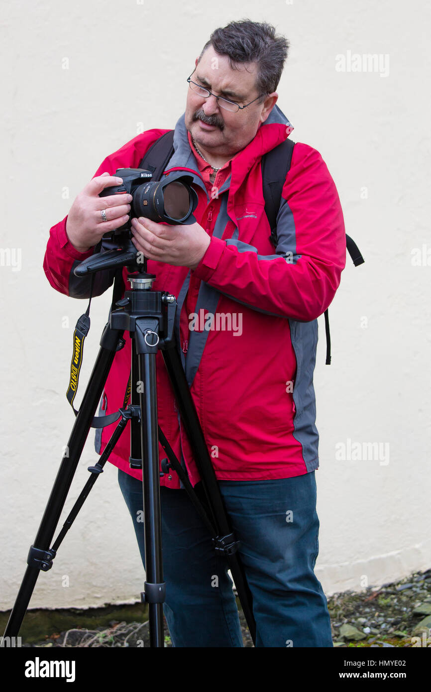 Photographe mâle, 50 ans avec l'appareil photo et une veste rouge Banque D'Images