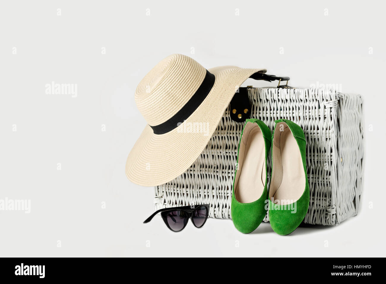 Valise en osier blanc, womens chapeau, lunettes et chaussures vert. Focus sélectif. Banque D'Images