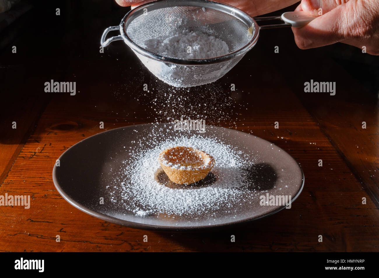 Saupoudrer de sucre en poudre biscuits fraîchement cuits au four Banque D'Images