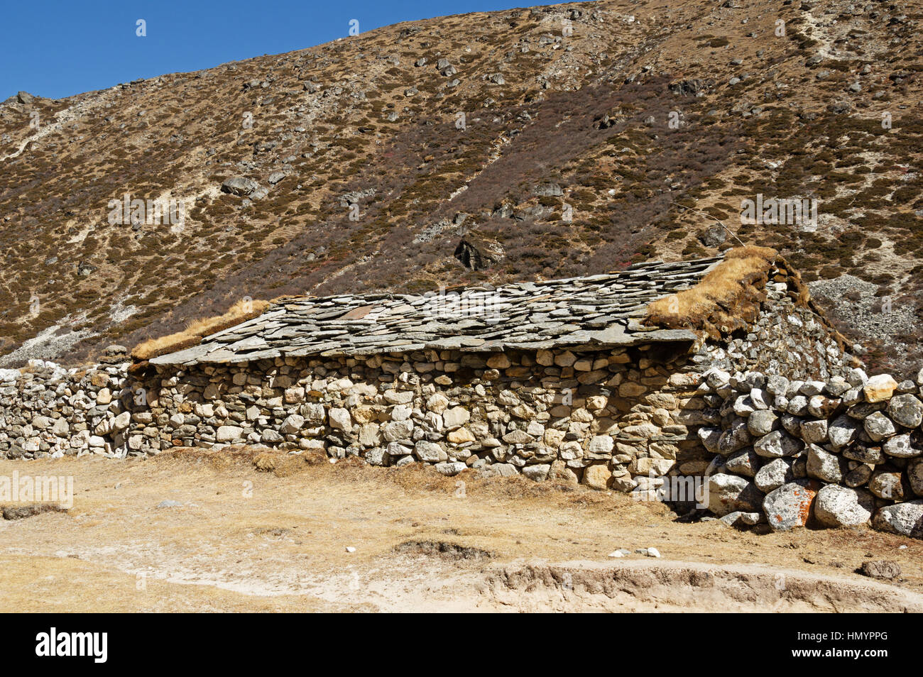 Vieille maison en pierre traditionnelle dans la région himalayenne du Népal avec toit en pierre Banque D'Images