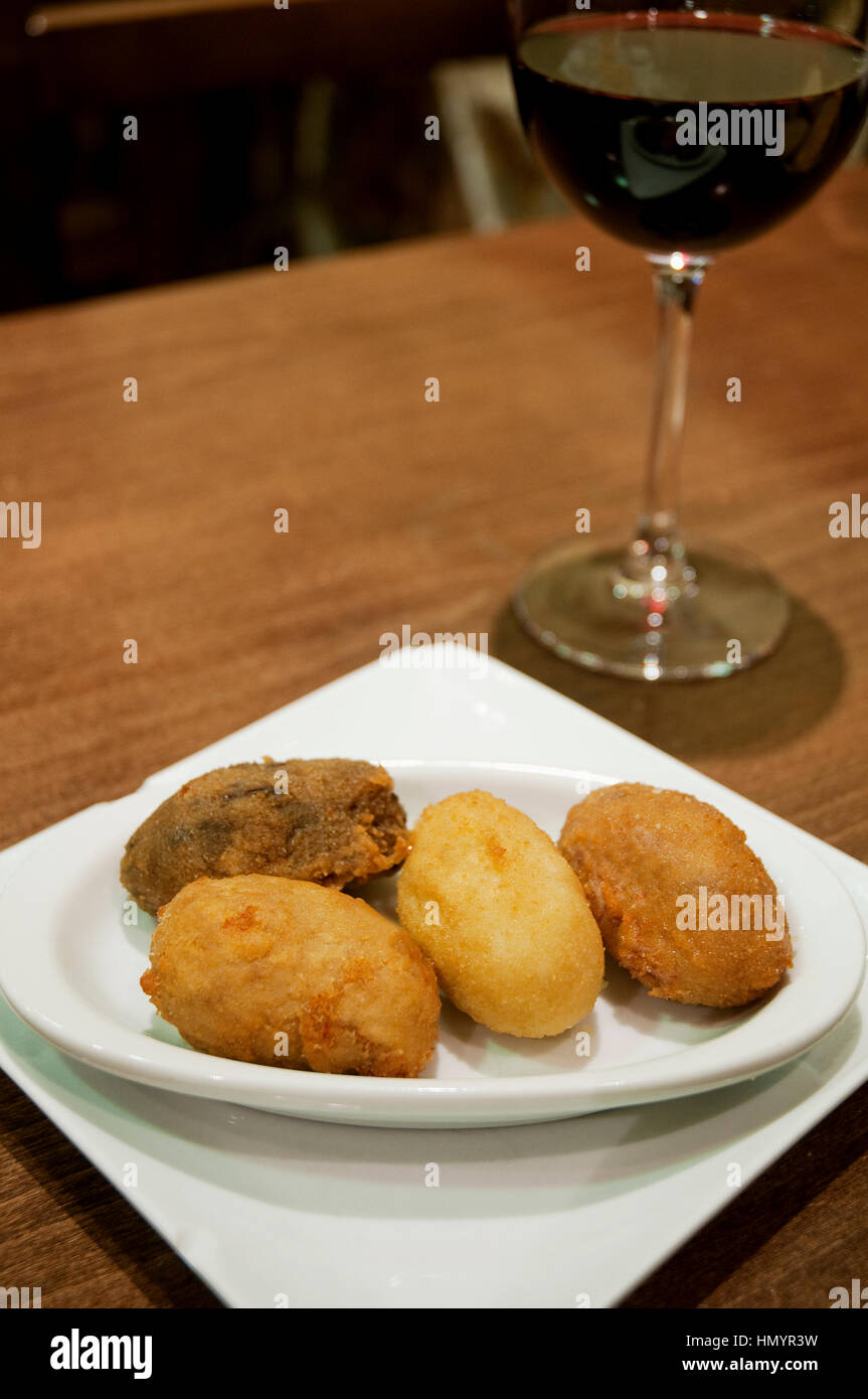 Servir les croquettes et le vin rouge. L'Espagne. Banque D'Images