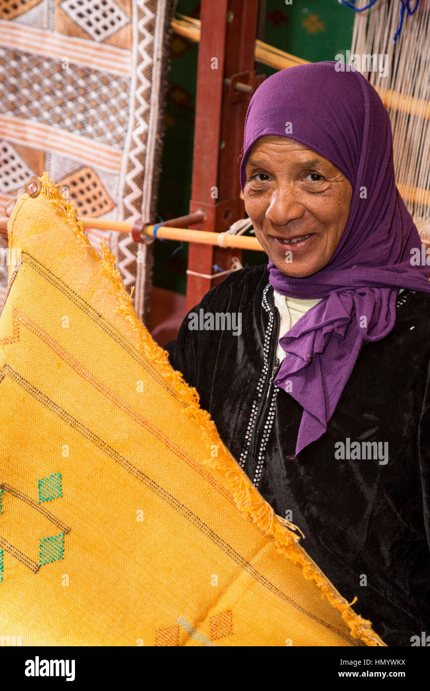 Le Maroc. Femme berbère Amazigh Affichage Tapis, Ksar Ait Benhaddou, un site du patrimoine mondial. Banque D'Images