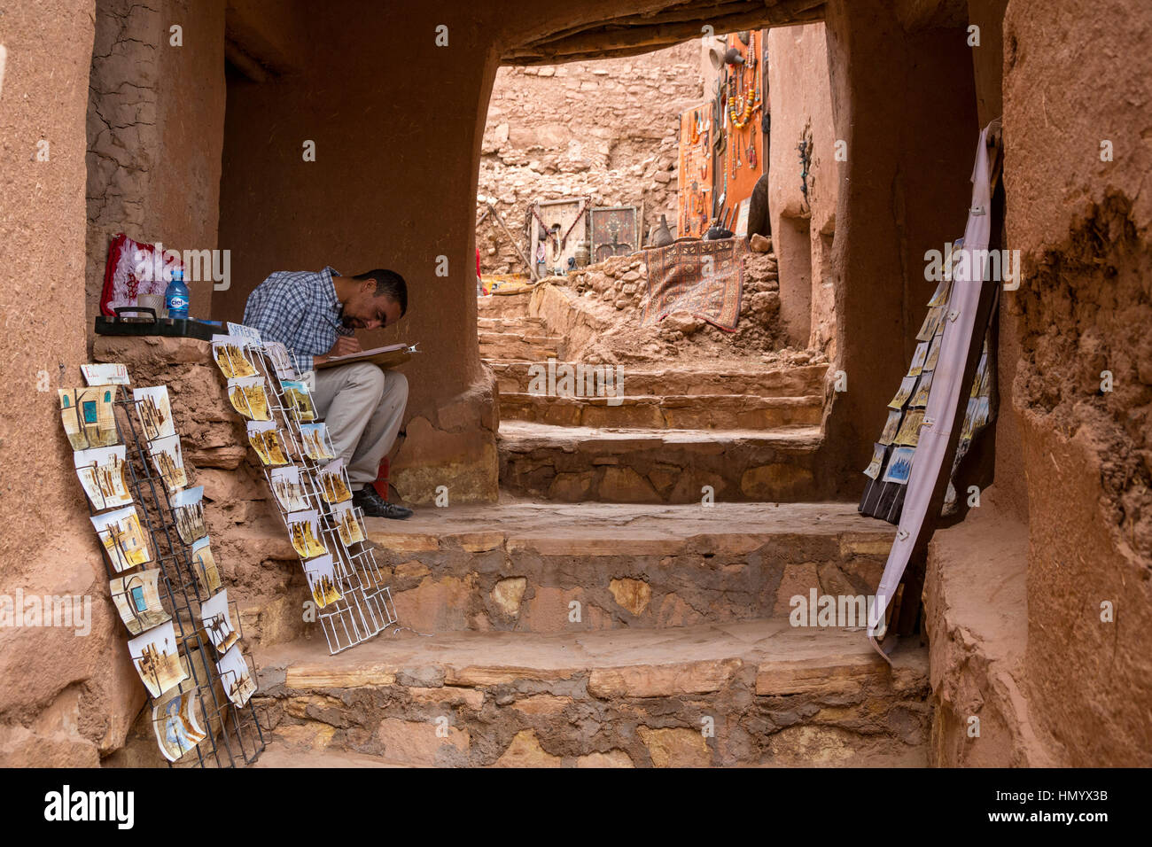 Le Maroc. Vendeur dans l'espoir de vendre des cartes postales et de travail artistique. Ksar Ait Benhaddou, un site du patrimoine mondial. Banque D'Images