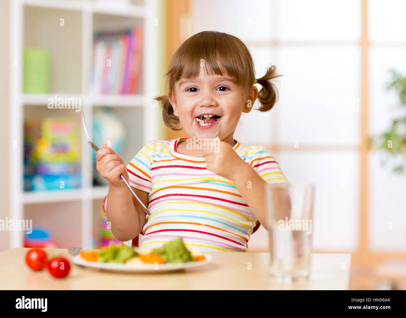 Funny enfant fille a un dîner à la maternelle ou la crèche prix Banque D'Images