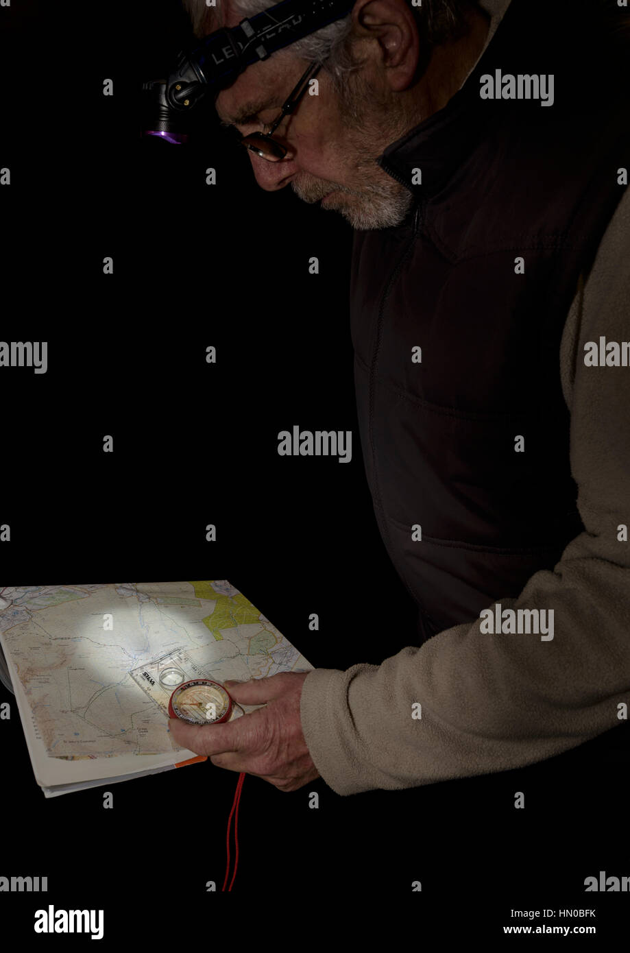 Lecture de carte de nuit avec une lampe frontale. Banque D'Images
