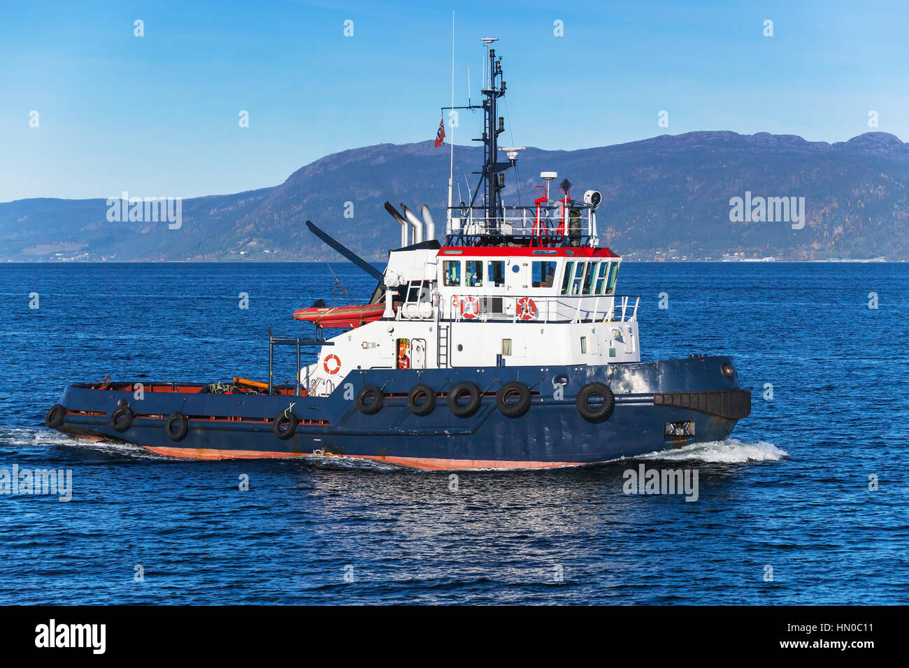 Tug boat avec superstructure blanc en cours, vue de côté. Trondheim, Norvège Banque D'Images