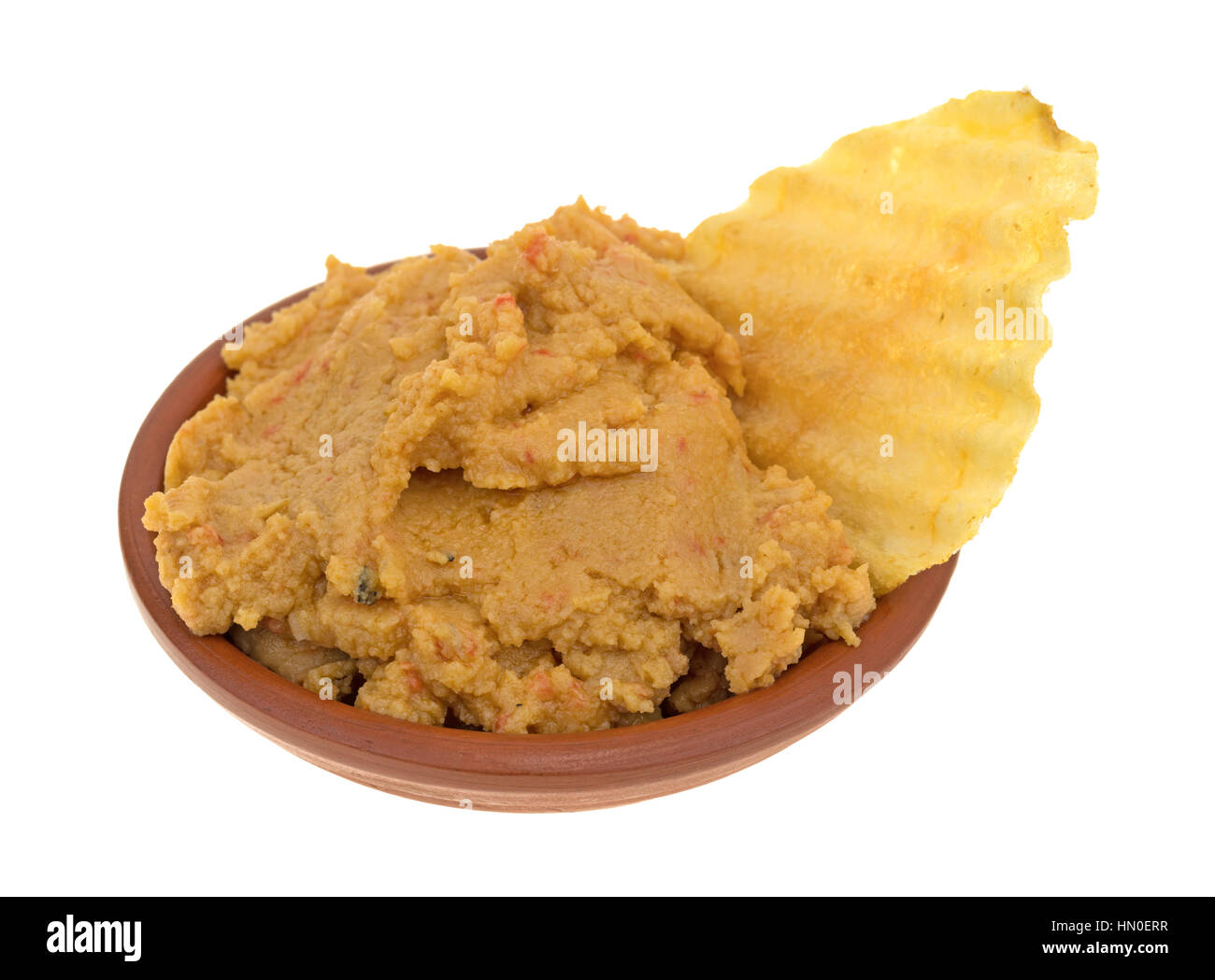 Un petit bol de l'hoummos artichaut trempette avec une puce de pommes de terre dans l'aliment isolé sur un fond blanc. Banque D'Images