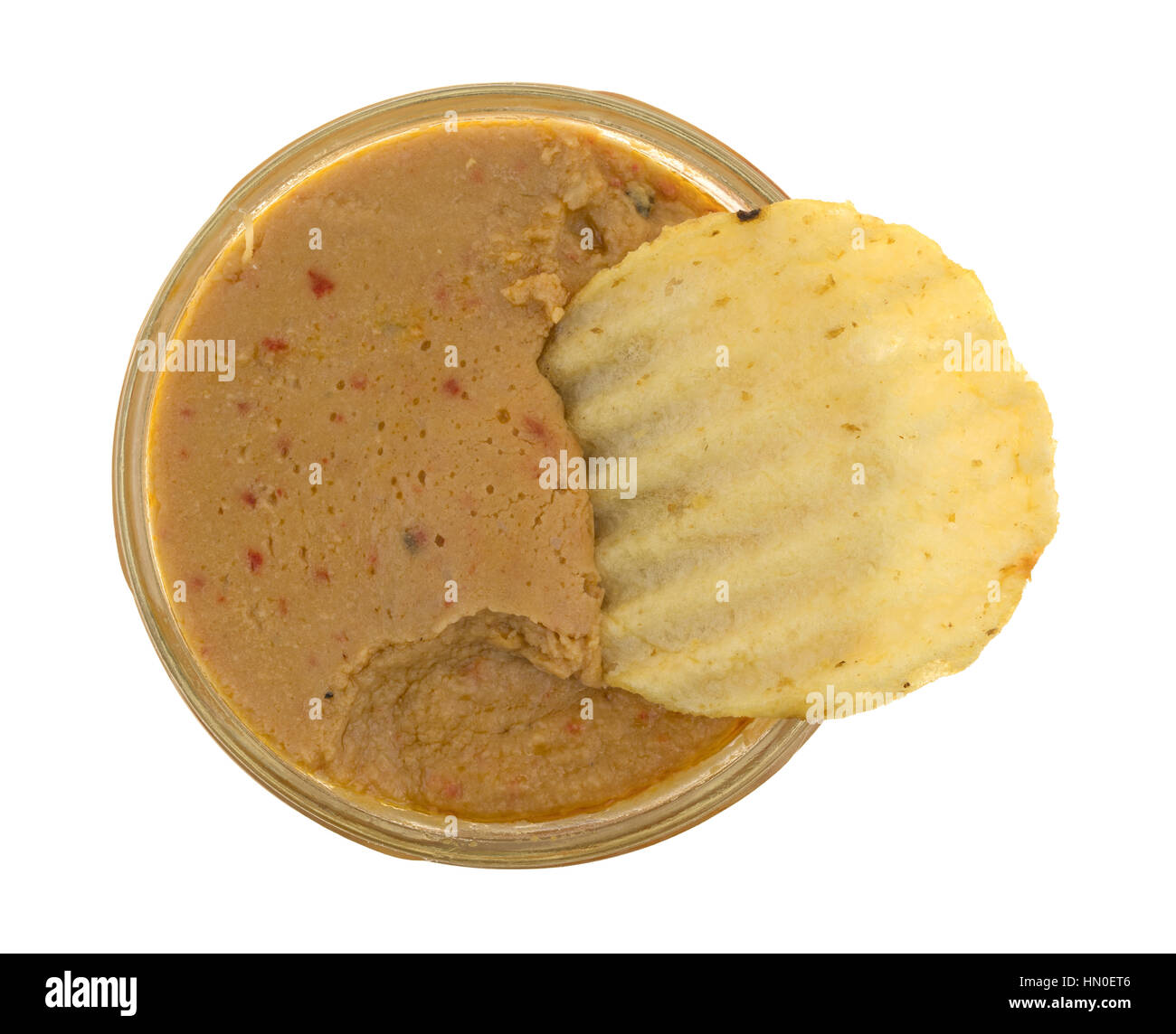 Dip d'Artichaut à l'hummus dans un pot ouvert avec une puce de pommes de terre dans l'aliment isolé sur un fond blanc. Banque D'Images