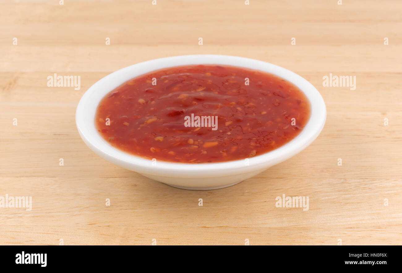 Poulet sauce piment chaud dans un petit bol sur une table en bois. Banque D'Images