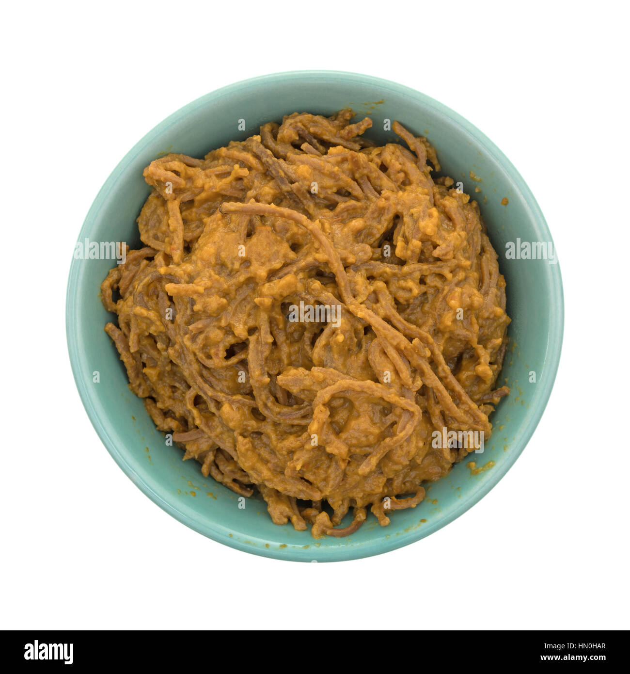 Vue de dessus d'une assiette de spaghetti avec sauce soja tomate dans un bol vert isolé sur un fond blanc. Banque D'Images