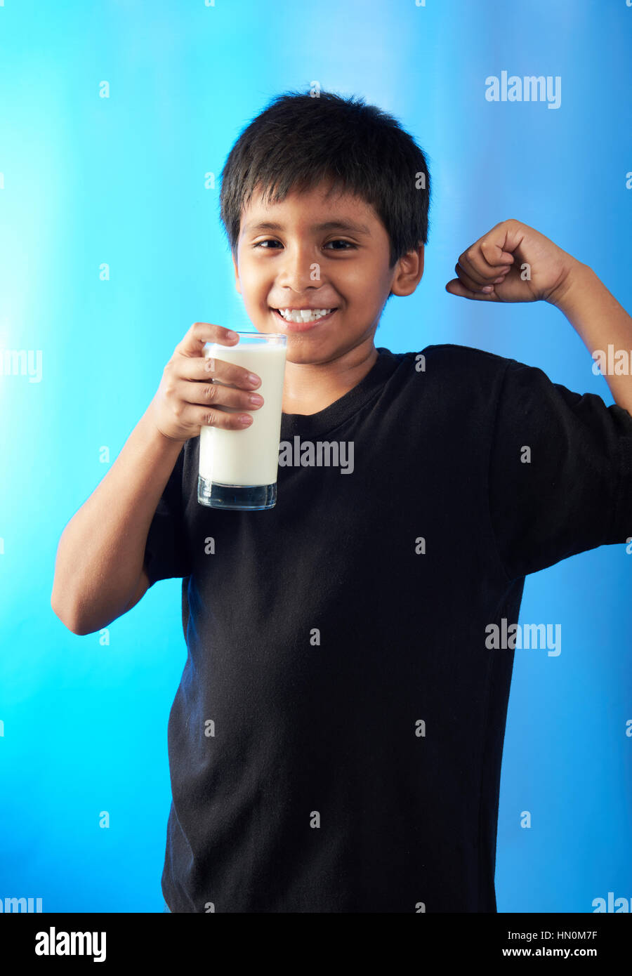 Muscle boy showing lait holding isolé sur fond bleu Banque D'Images