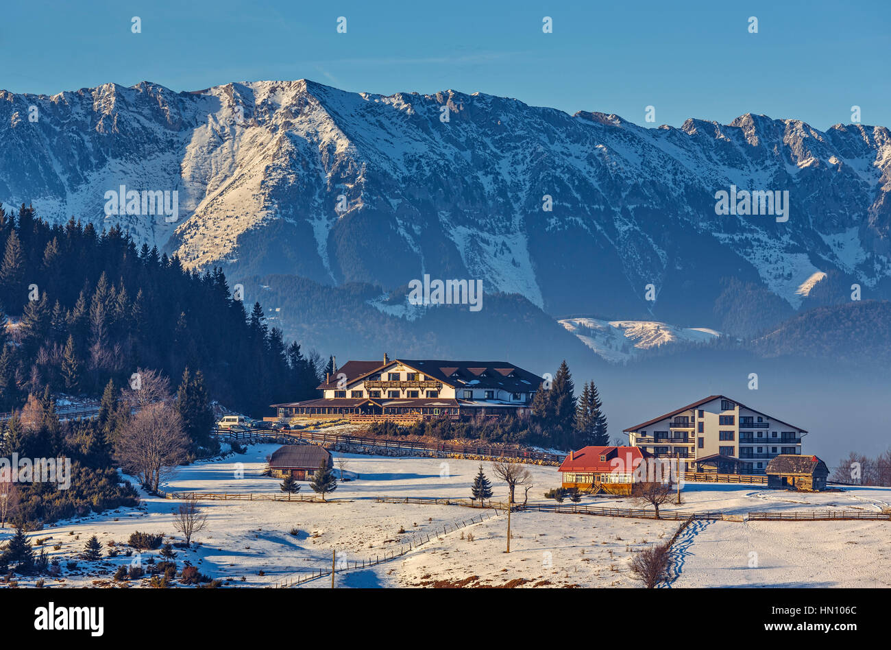 Beaux paysages d'hiver enneigés majestueux avec Piatra Craiului, chalet ou d'un logement dans les bâtiments Fundata Aparthotel Gallahaus, station touristique de la Roumanie. Banque D'Images