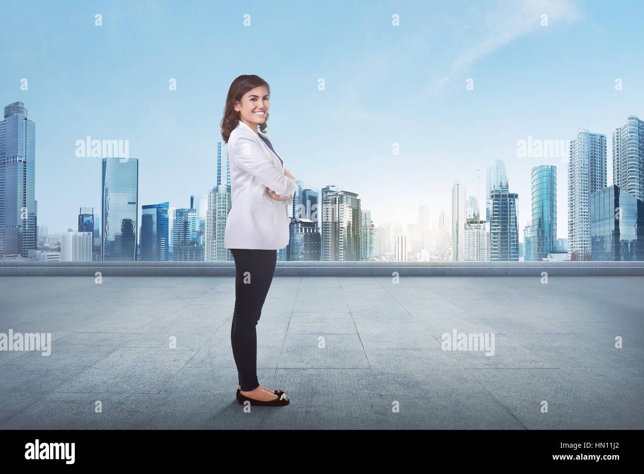 Portrait of a young asian business woman avec bras croisés devant cityscape background Banque D'Images