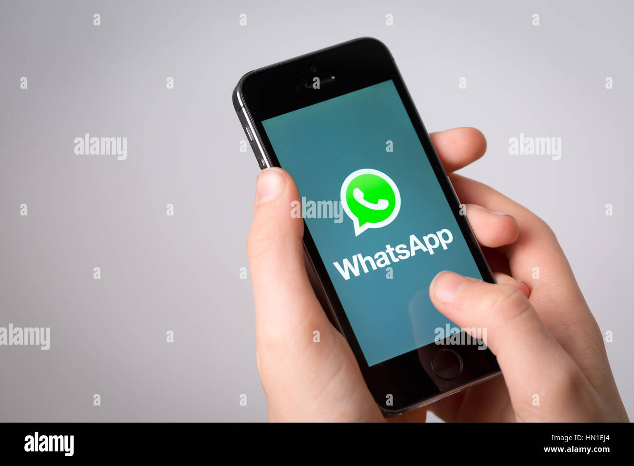 Un adolescent en utilisant WhatsApp sur un téléphone mobile Banque D'Images