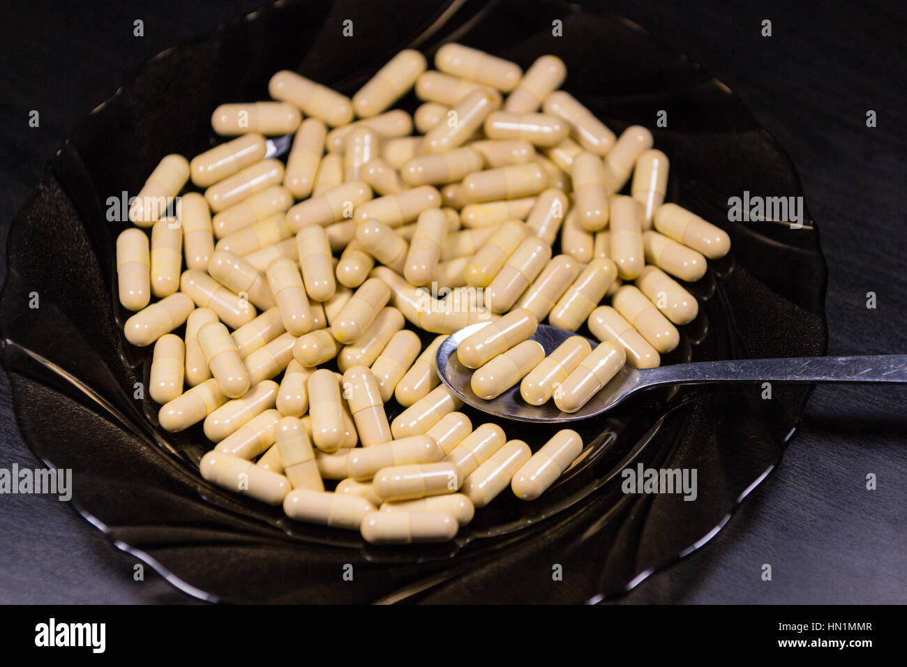 Cuillère de capsules de médicaments sur une assiette. Symbole de la toxicomanie, de la saine alimentation et de mode de vie minceur, régimes et Banque D'Images