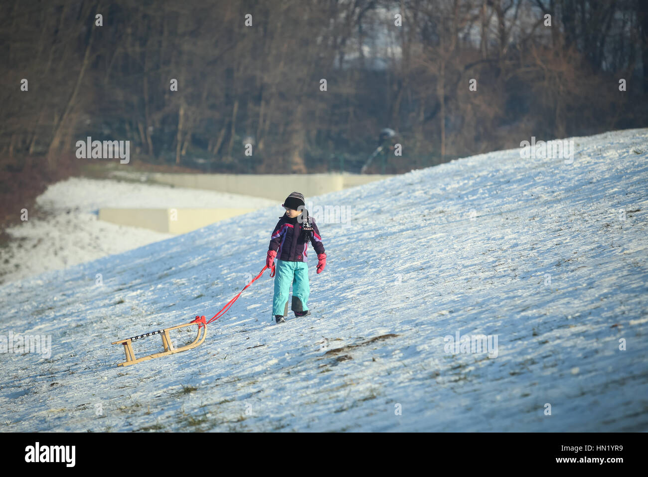 ZAGREB, CROATIE - 15 janvier 2017 : un garçon tirant le traîneau jusqu'à la colline à l'heure d'hiver à Zagreb, Croatie. Banque D'Images