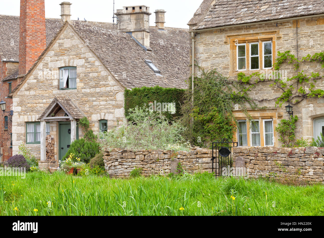 Miel traditionnel anglais golden brown lapidé cottages dans un village rural avec paroi/jardins, sur une journée ensoleillée d'été Banque D'Images