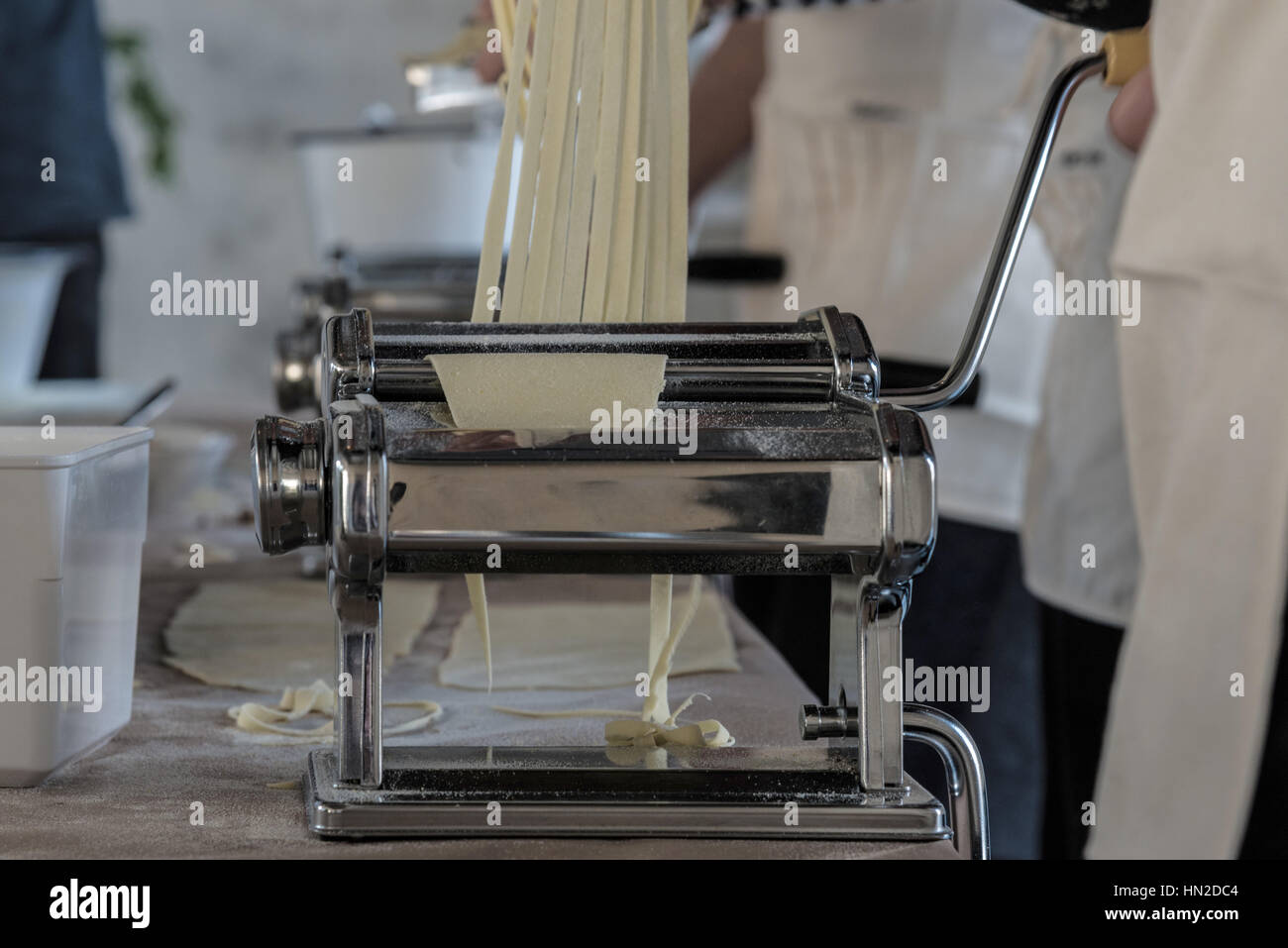 Personne l'exploitation d'une machine à pâtes couper la pâte en noodles Banque D'Images