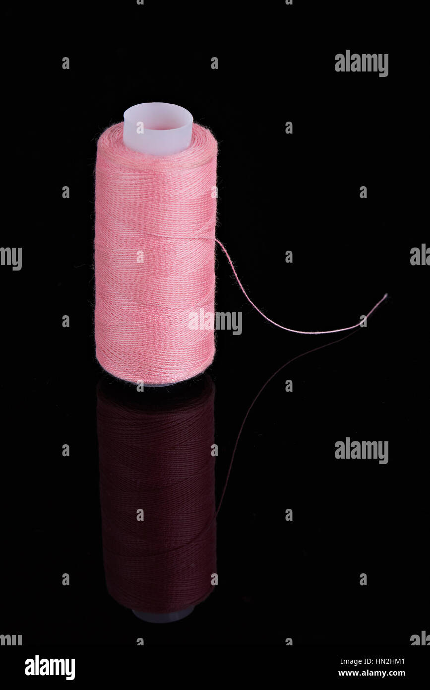 Un fil isolé de fibre rose sur fond noir Banque D'Images