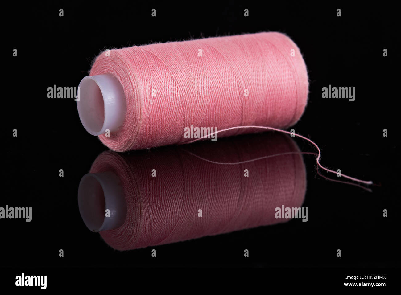 Close up of pink thread isolé sur fond noir Banque D'Images