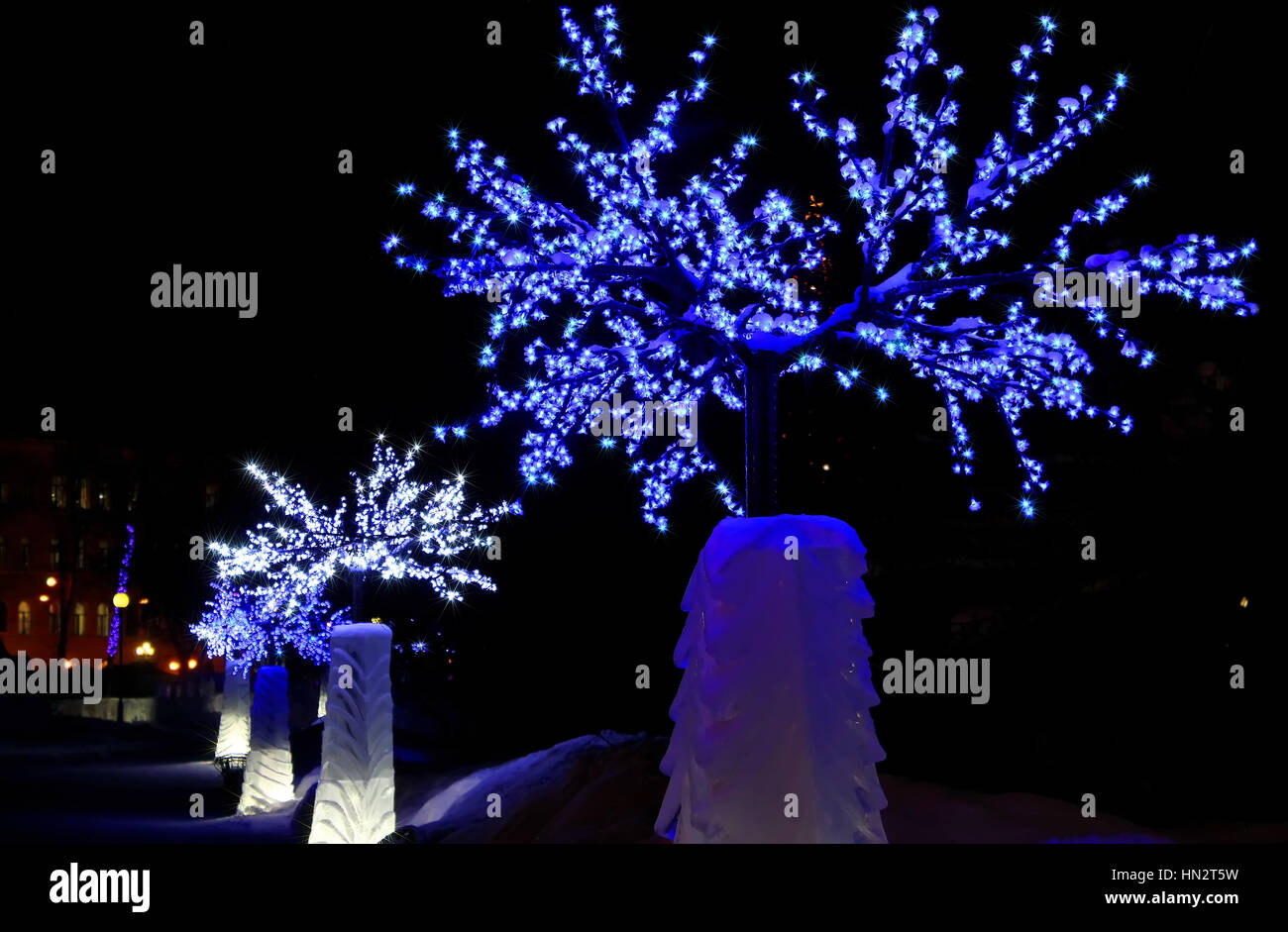 Décorations de Noël glace scintillante arbre avec des fleurs à la figure de glace la nuit avec des lumières Banque D'Images