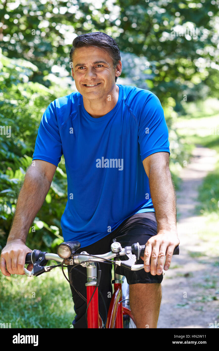 Vélo homme mûr le long du chemin dans la campagne Banque D'Images