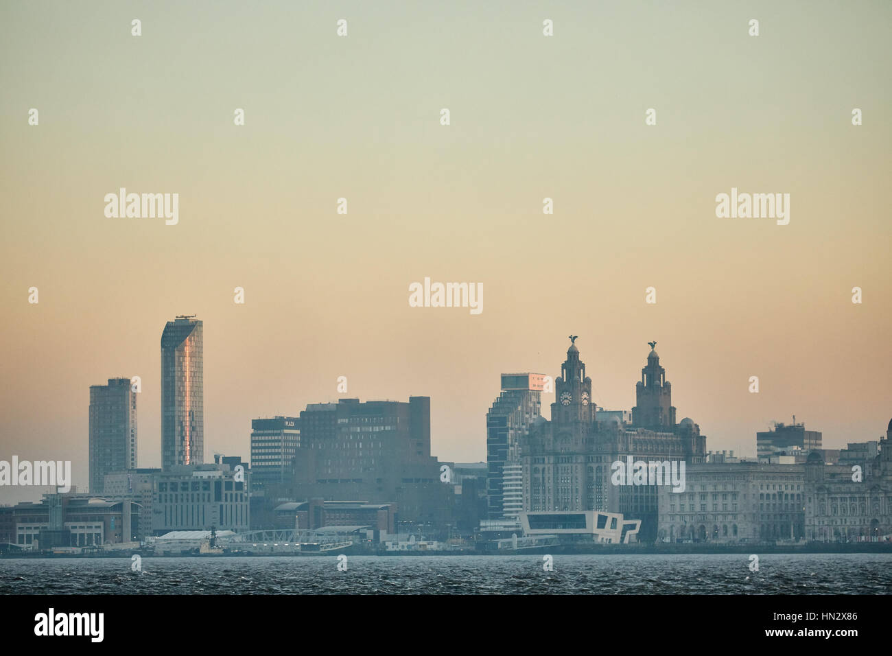 Du côté de la rivière Birkenhead sur la Mersey Orange ciel aube sur le centre-ville de Liverpool monument waterfront Skyline dans le Merseyside, Banque D'Images