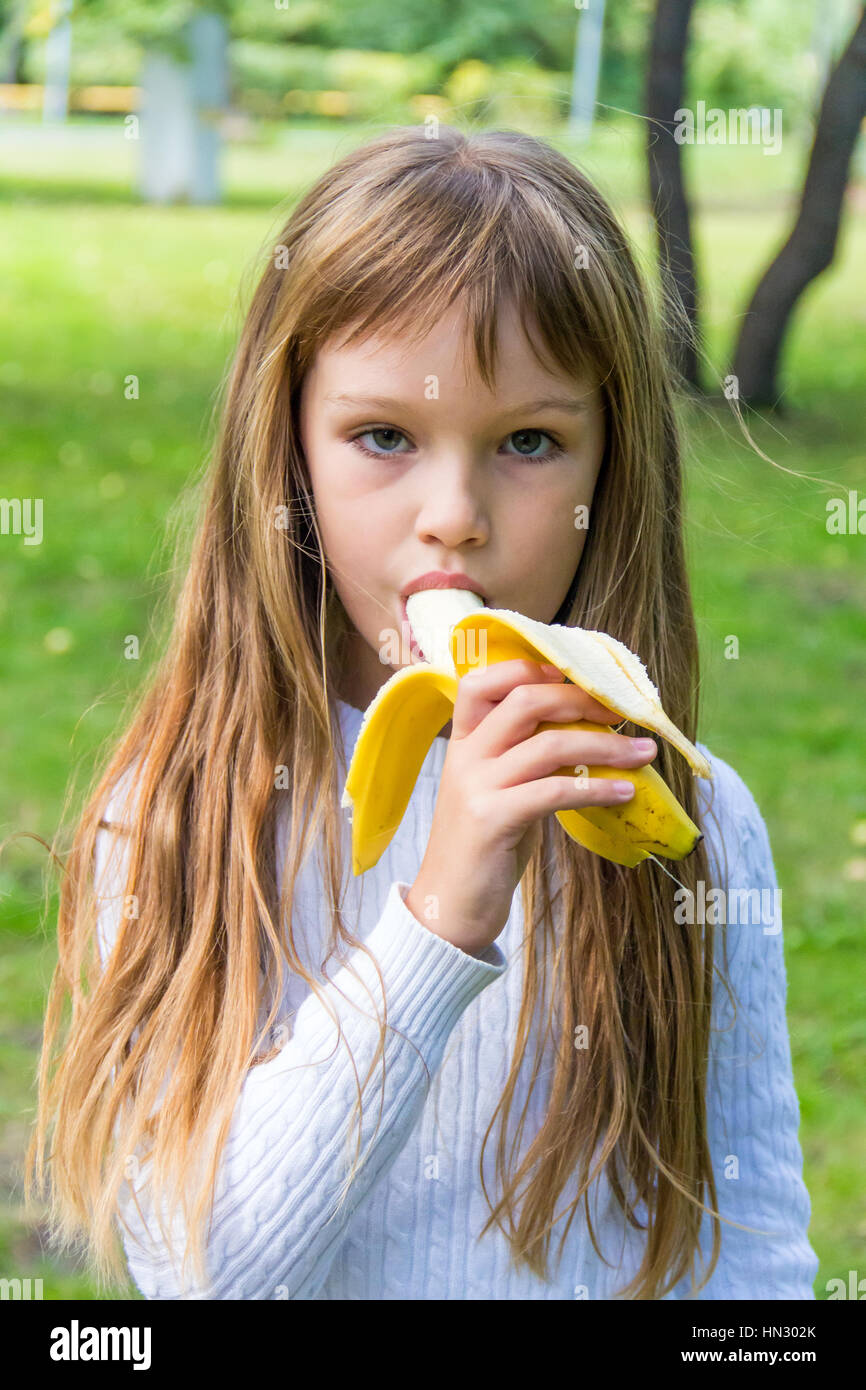 Photo de fille mangent la banane en été Banque D'Images
