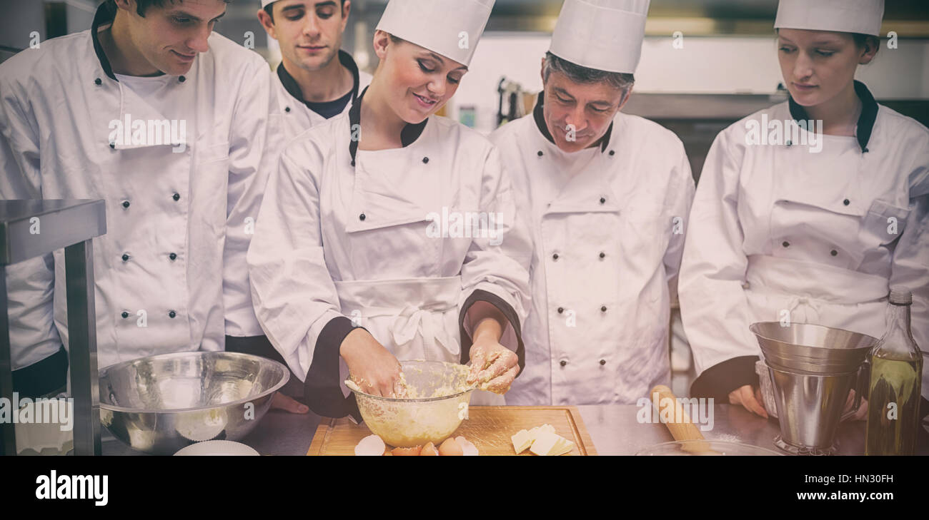 Chef pâtissier, montrer aux élèves la façon de préparer la pâte dans la cuisine Banque D'Images