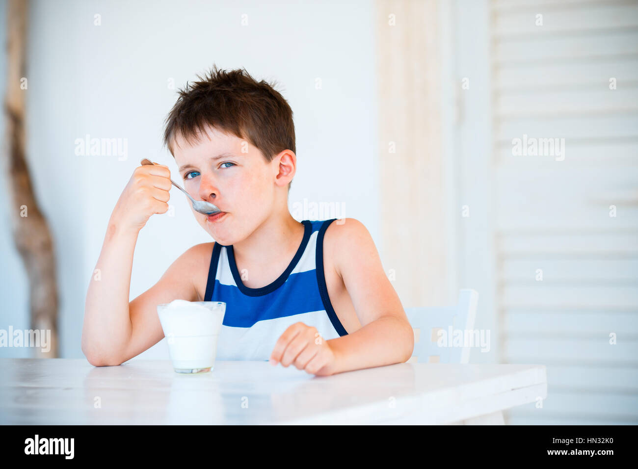 Portrait de petit garçon refuse de manger de délicieux yaourts Banque D'Images