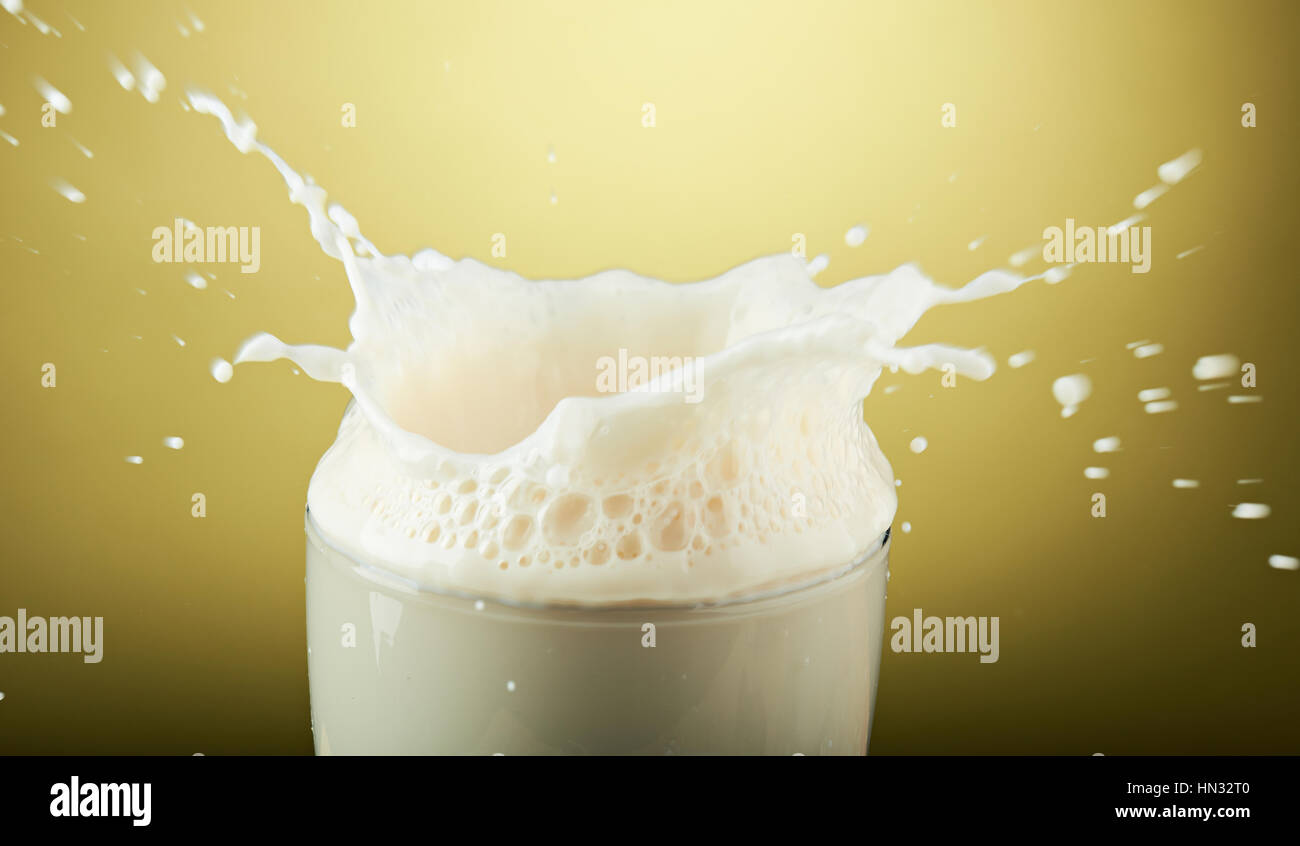 Nuage de lait en verre isolé sur fond jaune Banque D'Images