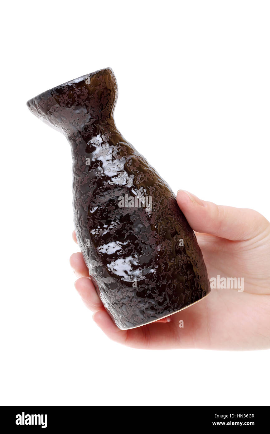 Main tenant le saké japonais bouteille isolé sur fond blanc Banque D'Images