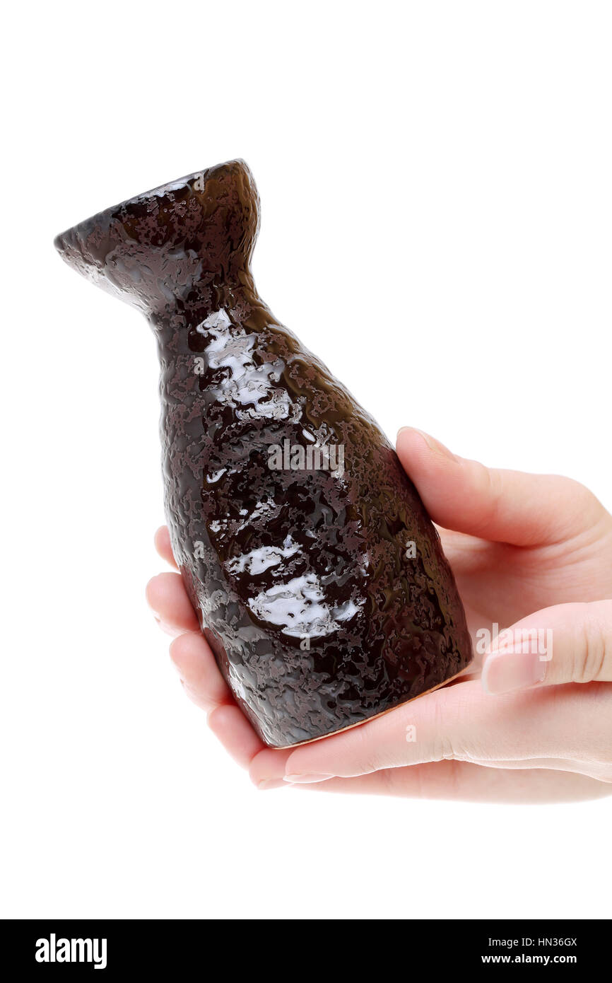 Main tenant le saké japonais bouteille isolé sur fond blanc Banque D'Images