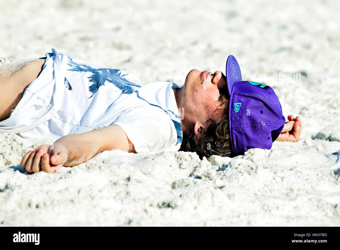 Panama City Beach, en Floride. Les vacances de printemps, 2011. Jeune homme évanoui sur la plage. Banque D'Images