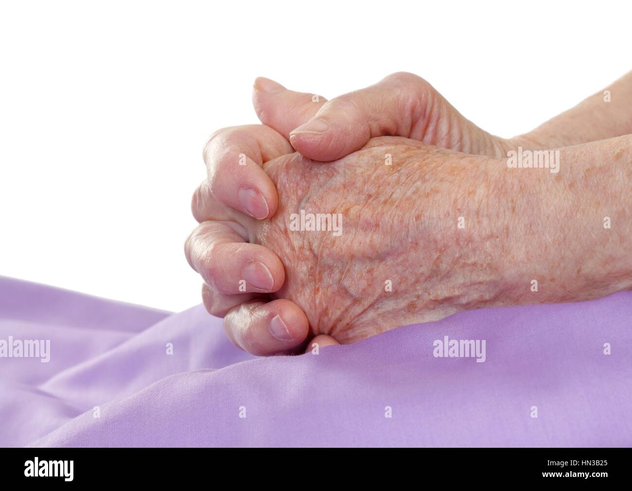Close-up of old mains priant sur le lit Banque D'Images